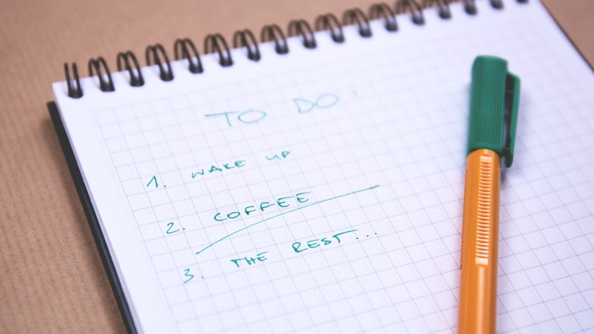 Handwritten to-do list on graph paper notebook with pen. Ideal for organizing tasks.